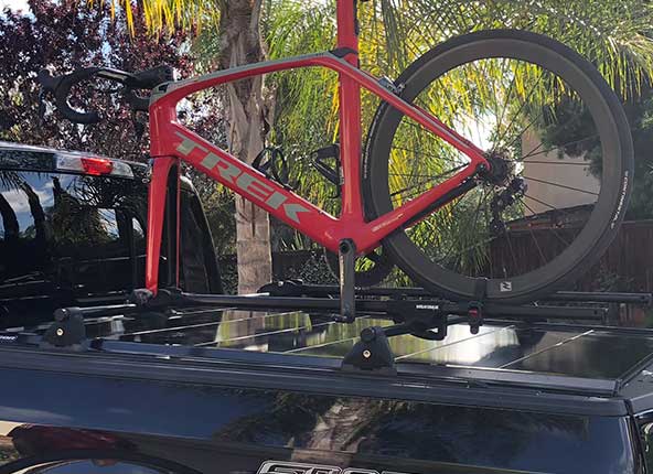 A man strapping coolers to the top of the cover.
